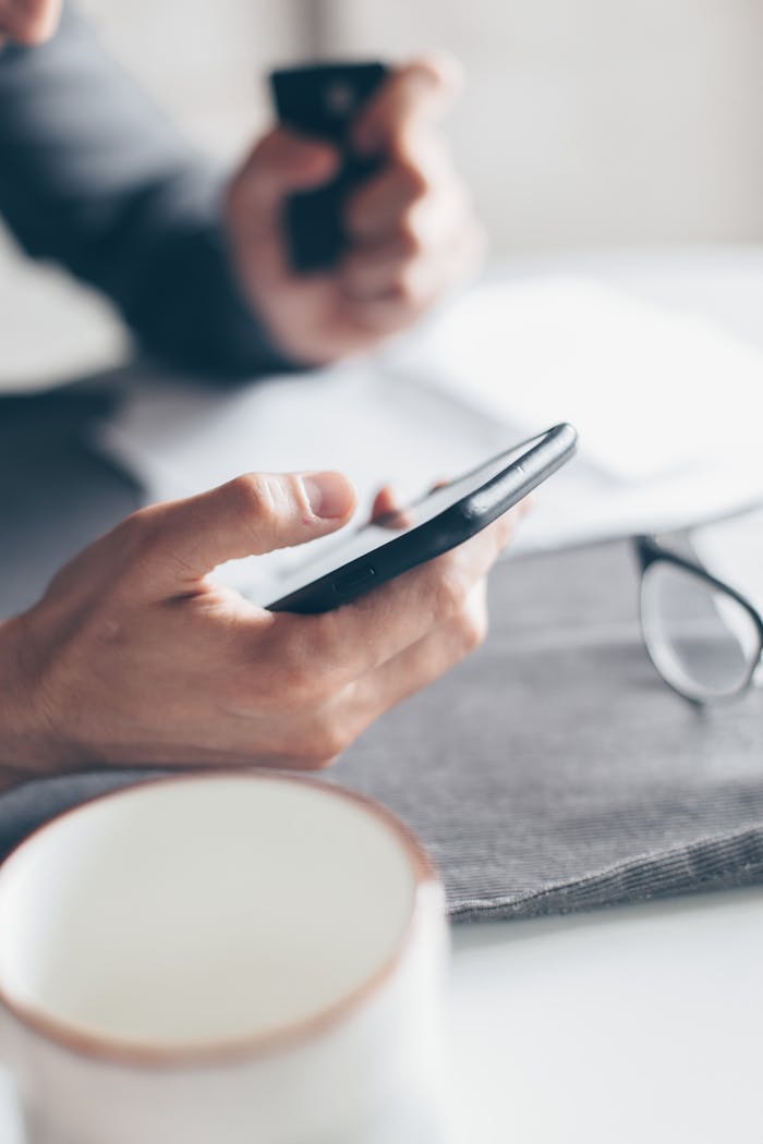Hands holding a smartphone and credit card for online payment, emphasizing cashless transactions.